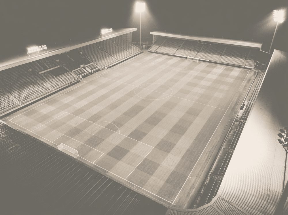 Duotone photograph of a floodlit stadium pitch for EA Sports